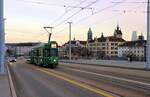 Bald endet der Einsatz von Vierachsern in Basel: Mit der Silhouette von Kleinbasel und einem Turm des Chemiekonzerns Roche im Hintergrund kommt Be 4/4 487 mit Anhänger 1463 auf die Dreirosenbrücke herauf. 7.Dezember 2021 