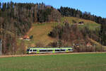 Die ehemalige VHB (Vereinigte Huttwil-Bahnen) / Strecke der ursprünglichen Huttwil-Wolhusen Bahn (HWB): Eine BLS NINA fährt an innerschweizerischen Bauernhäusern vorbei nach Hüswil. 31.Dezember 2021  