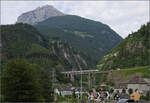 RABe 501 015 'Kanton St. Gallen' und RABe 501 027 'Kanton Schaffhausen' (im Bild) auf der Chärstelenbachbrücke über Amsteg. Im Hintergrund das Bristental und der Chli Windgällen. Juli 2024.