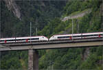 RABe 501 015 'Kanton St. Gallen' und RABe 501 027 'Kanton Schaffhausen' auf der Chärstelenbachbrücke über Amsteg. Juli 2024.