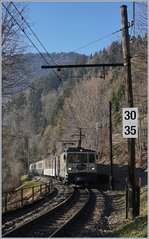 Im Wald, kurz vor Les Avants und noch unter alten Fahrleitungsmasten, fährt eine MOB GDe 4/4 mit ihrem Belle Epoque Zug Richtung Zweisimmen.