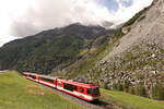 Der Bergsturz von Randa: Triebwagen ABDeh4/10 2013 auf der Fahrt nach Randa und Zermatt hat den Scheitelpunkt der Umfahrungsstrecke fast erreicht. Oben sieht man den als gefährlich eingestuften Bisgletscher, der über einem sehr steilen Berg ...