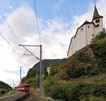 Stalden, MGB: Blick hinauf zur Kirche Stalden, mit einem Zug mit der Lok 3. Die Lok zieht weder den Glacier-Express noch einen Güterzug, sondern einen 'normalen' Pendelzug, am Ende mit dem ehemaligen BVZ-Steuerwagen BDt 2241. 30.August 2025 