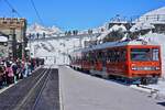 Zahlreiche Reisende warten am Mittag des 10.05.2024 in der Bergstation der Gronergratbahn auf den gleich eintreffenden Zug zurück ins Tal nach Zermatt, daneben der Bhe 4/8 3053