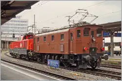 Die SBB Historic Ae 3/6 III 10264 schiebt in Lausanne ein mächtiges ETCS Gerät in Form einer Aem 940 vor sich her.