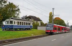 Kurz nach Verlassen des Bahnhofs Ins Dorf fahren die Be 2/6 510 und 503 am 11.10.2025 am ehemaligen BTI-Triebwagen BDe 4/4 5, später BRe 4/4 516 und heute Restaurant 